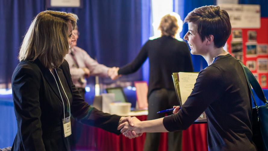 Two women shake hands during a career event