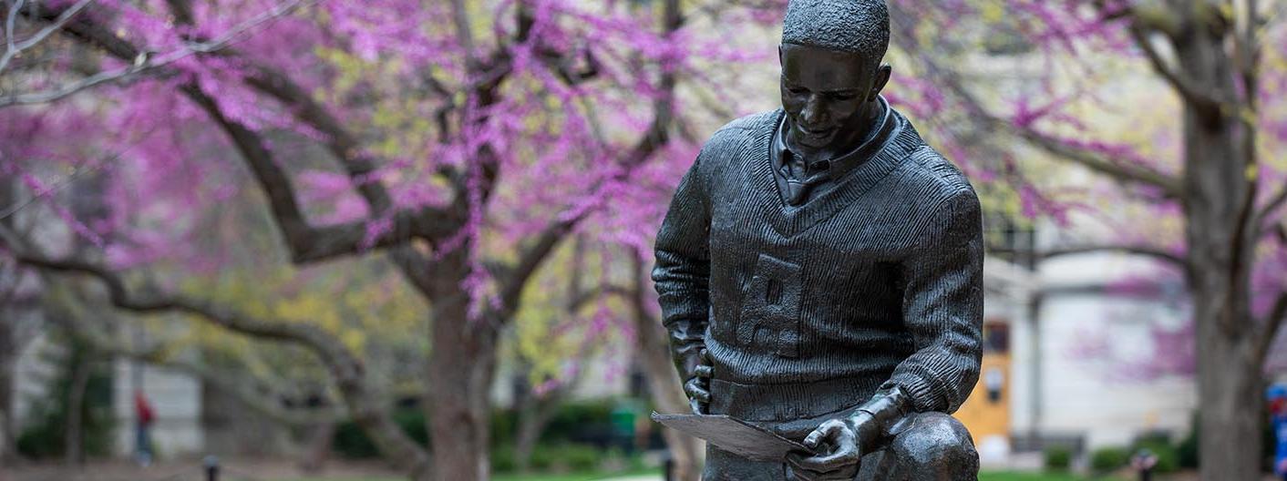 杰克·特里斯雕塑的特写，在春天的一天，紫荆树盛开