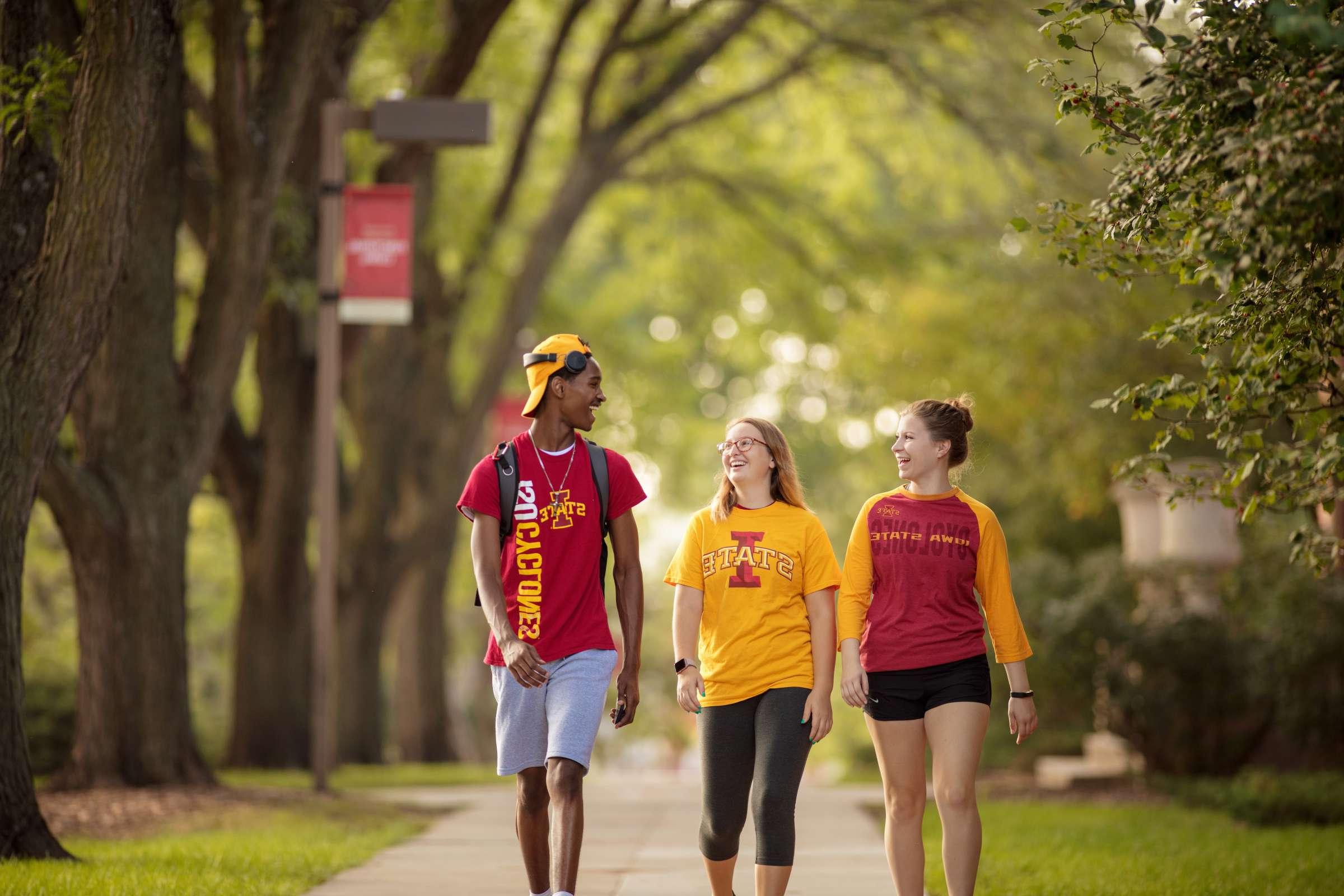 Three students walking on campus. 